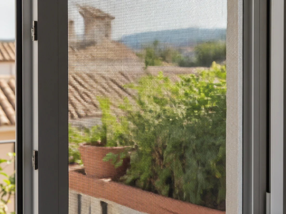 Mosquitera enrollable instalada en una ventana de Sant Boi